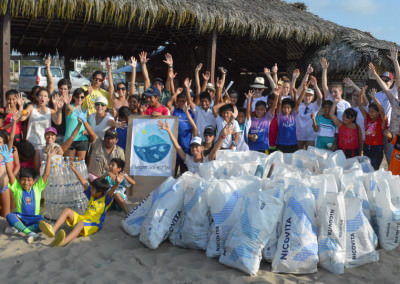 Group of people after a beach cleanup with collected trash